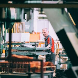 Trabalhador operando máquina industrial em ambiente fabril