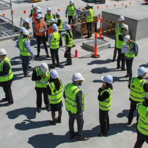Equipe de trabalhadores com equipamentos de proteção durante reunião de segurança